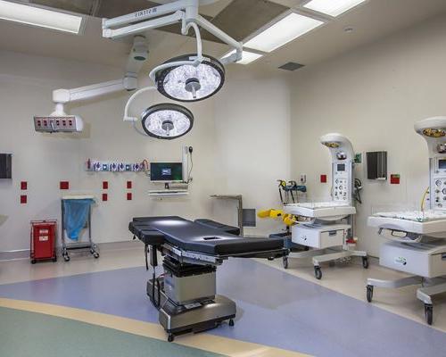 Photo of cesarean section room at Jupiter Medical Center. Delivery bed, big lights, and newborn warming stations.